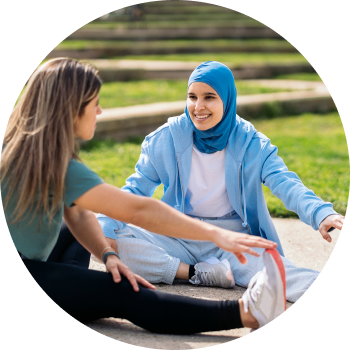 Two young girls stretching out their legs getting ready for a yoga session